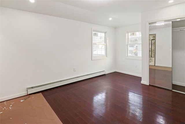 unfurnished bedroom with dark hardwood / wood-style floors, a closet, and baseboard heating