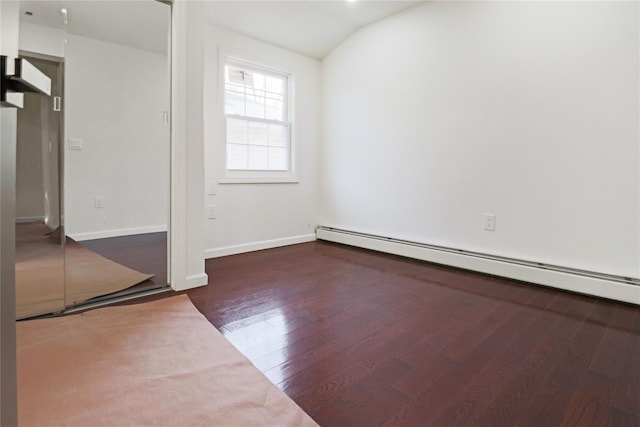 unfurnished room with a baseboard radiator, vaulted ceiling, and dark hardwood / wood-style flooring