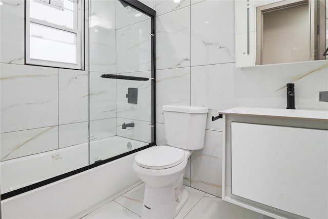 full bathroom featuring vanity, shower / bath combination with glass door, and toilet