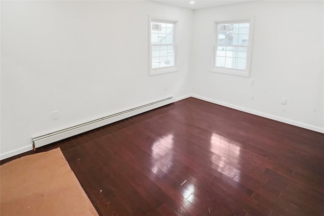 spare room with hardwood / wood-style floors and baseboard heating