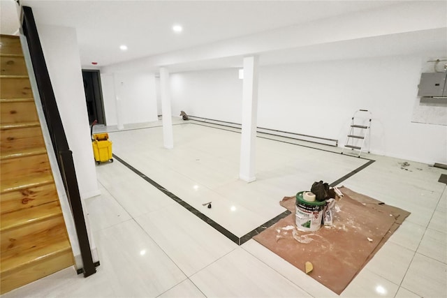 basement featuring electric panel and tile patterned flooring