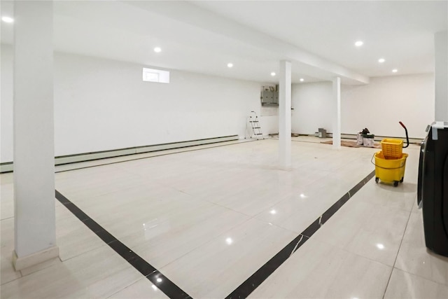 basement with a baseboard heating unit, electric panel, and light tile patterned flooring