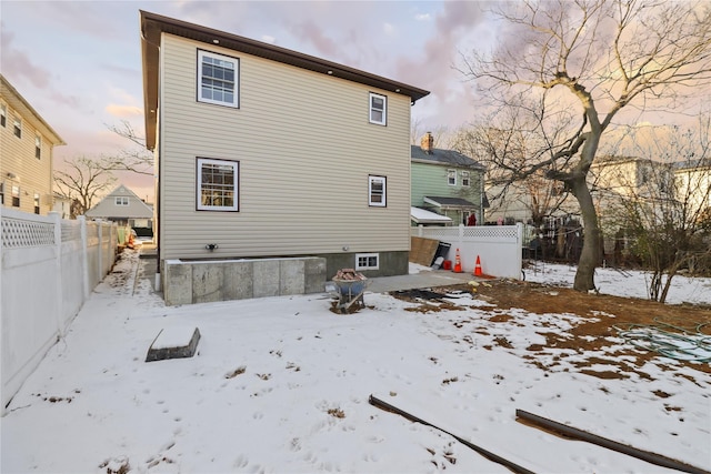 view of snow covered rear of property