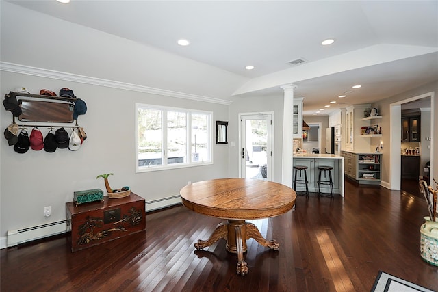 dining room with ornate columns, a baseboard radiator, vaulted ceiling, and dark wood-type flooring