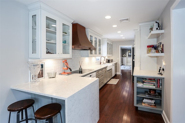 kitchen featuring white cabinetry, a kitchen breakfast bar, light stone counters, custom range hood, and kitchen peninsula