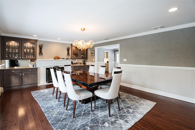 dining room with ornamental molding, dark hardwood / wood-style floors, and a notable chandelier