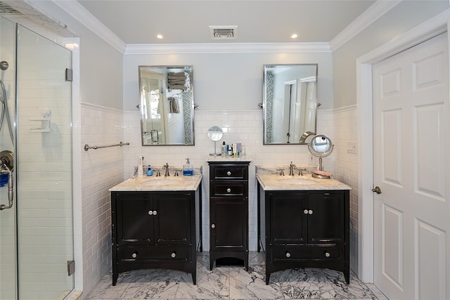 bathroom featuring a shower with door, vanity, ornamental molding, and tile walls