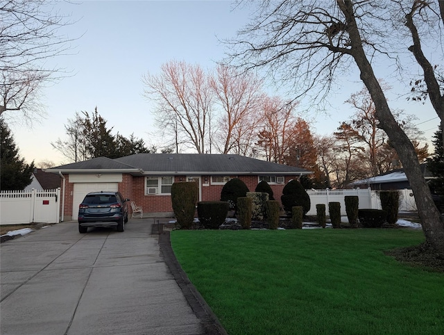 view of front facade featuring fence, an attached garage, brick siding, driveway, and a front lawn