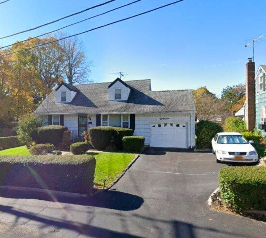 cape cod-style house featuring a garage