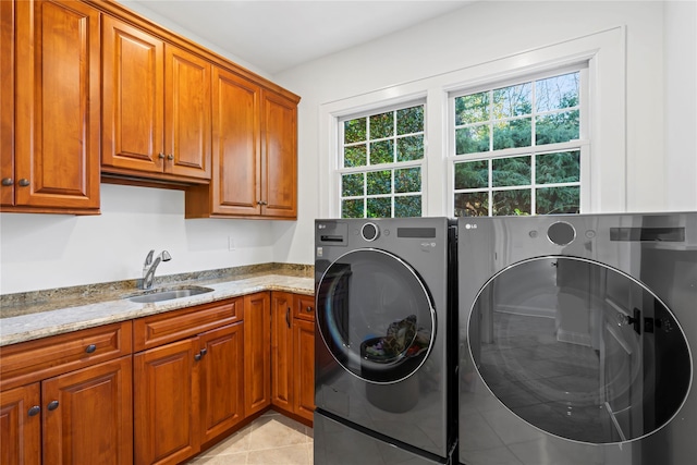 laundry room featuring cabinets, light tile patterned flooring, sink, and washer and clothes dryer