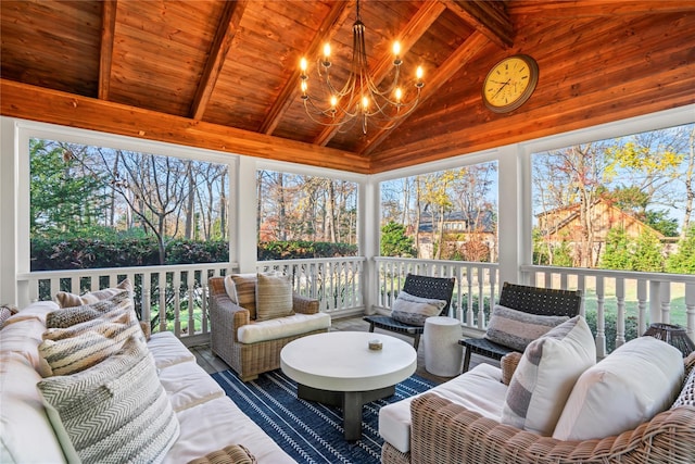 sunroom featuring lofted ceiling with beams, plenty of natural light, wood ceiling, and an inviting chandelier