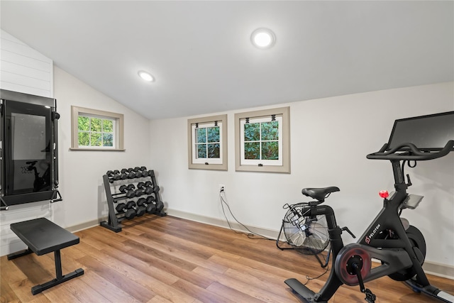 exercise room featuring lofted ceiling and light wood-type flooring