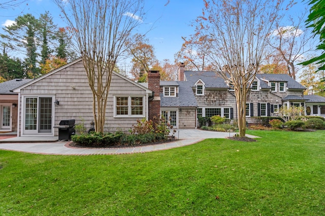 rear view of house featuring a lawn and a patio