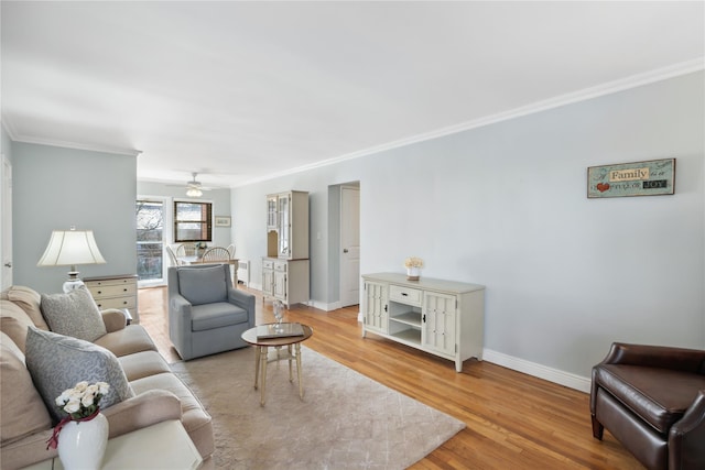 living room featuring crown molding, light hardwood / wood-style flooring, and ceiling fan