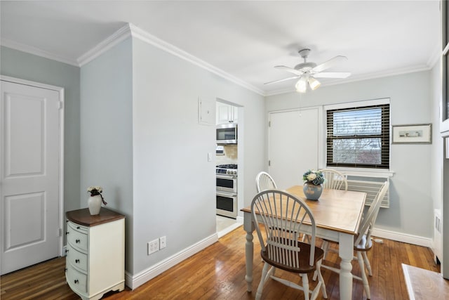 dining room featuring ornamental molding, dark wood-type flooring, and ceiling fan