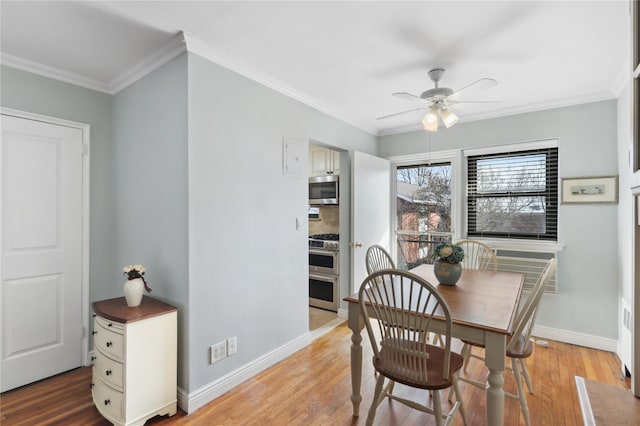 dining room with hardwood / wood-style flooring and crown molding