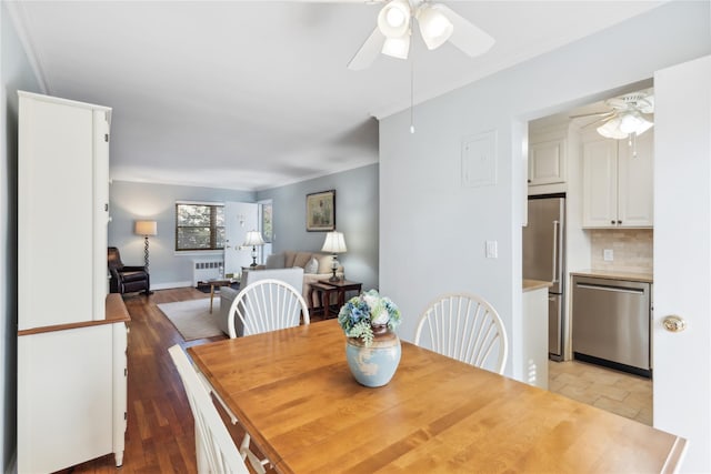 dining space with radiator, wood-type flooring, and ceiling fan