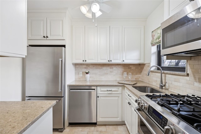 kitchen featuring stainless steel appliances, white cabinetry, sink, and decorative backsplash