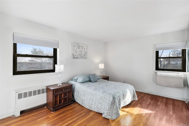 bedroom featuring wood-type flooring and radiator heating unit