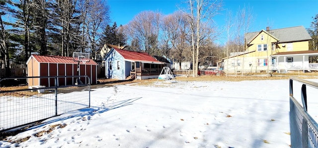 snowy yard featuring an outbuilding