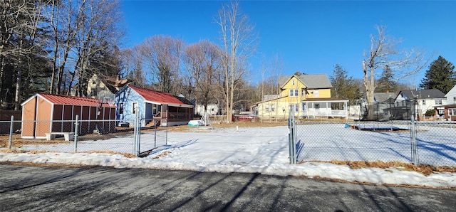 snowy yard featuring an outdoor structure and fence