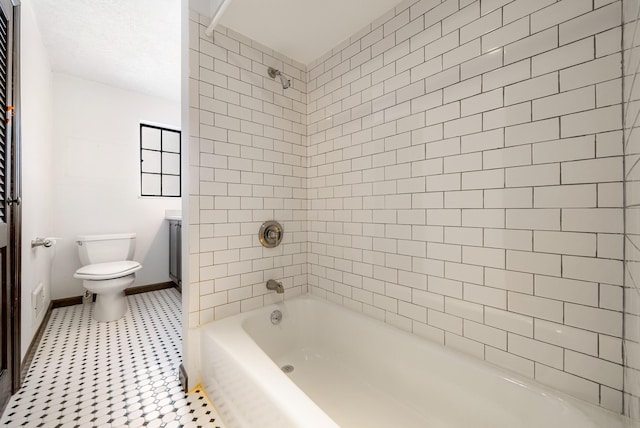 full bathroom featuring tiled shower / bath combo, vanity, and toilet