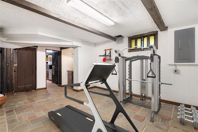 workout area featuring electric panel and a textured ceiling