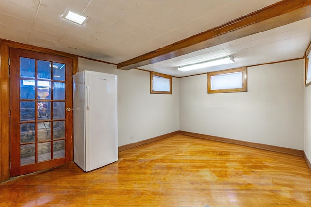 basement featuring white fridge and light hardwood / wood-style floors