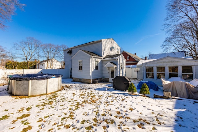 snow covered property with a covered pool