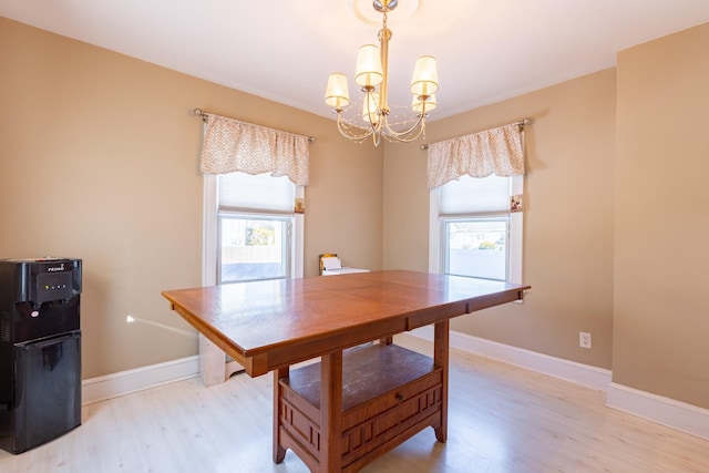 dining space featuring a healthy amount of sunlight, a chandelier, and light hardwood / wood-style flooring