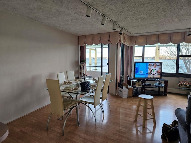 dining area featuring wood-type flooring and a textured ceiling