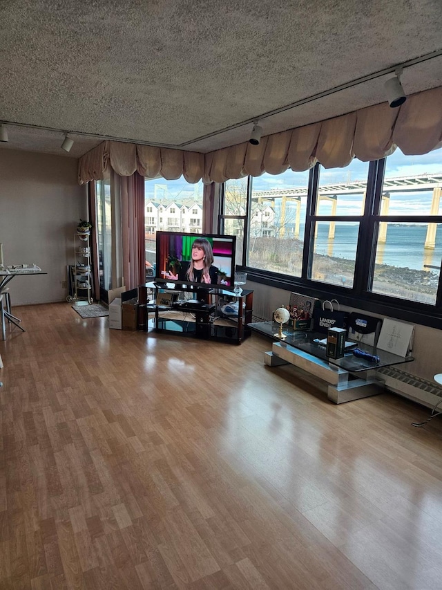 gym with track lighting, hardwood / wood-style floors, and a textured ceiling