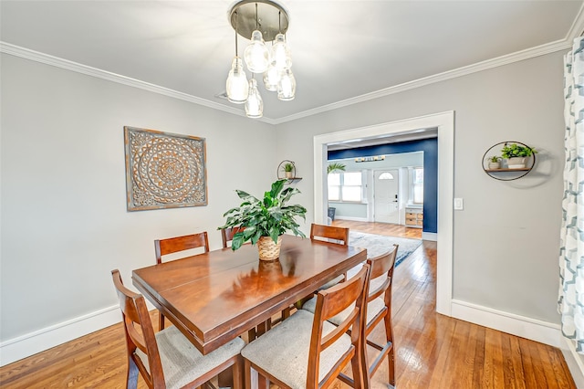 dining space featuring an inviting chandelier, wood-type flooring, and crown molding