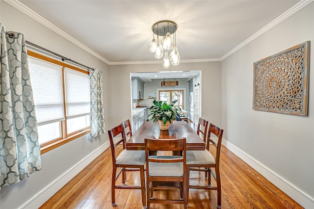 dining space featuring crown molding and light hardwood / wood-style flooring