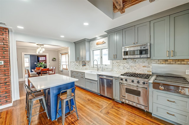 kitchen with a breakfast bar, sink, tasteful backsplash, a center island, and stainless steel appliances