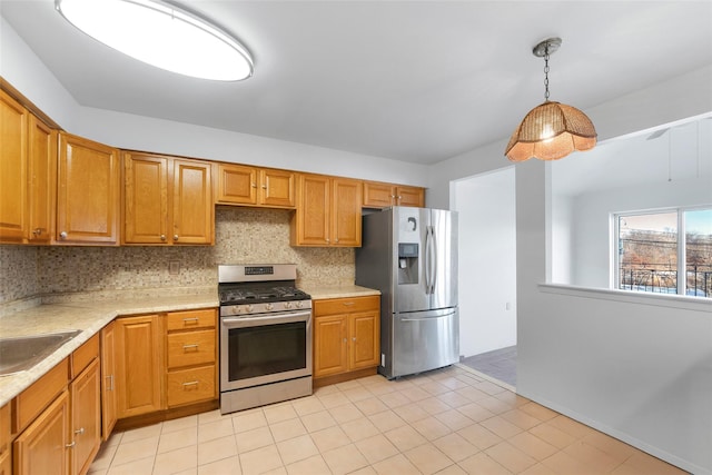 kitchen featuring pendant lighting, sink, appliances with stainless steel finishes, tasteful backsplash, and light tile patterned flooring