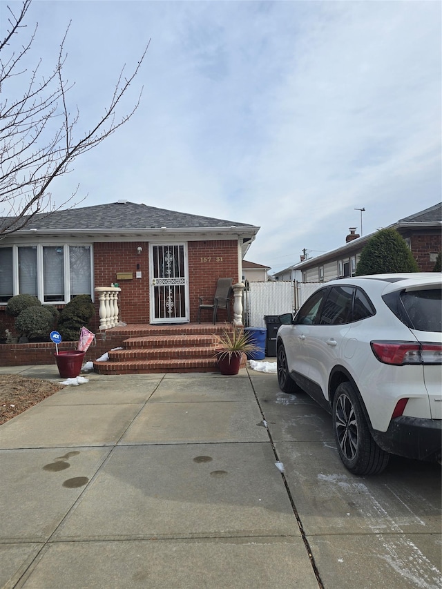 15731 80th St, Howard Beach, NY 11414 - view of front facade featuring a shingled roof and brick siding