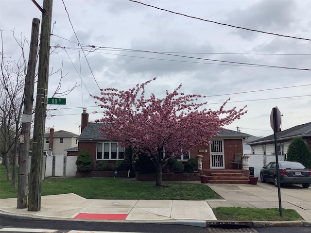 15731 80th St, Howard Beach, NY 11414 - obstructed view of property with fence, a front lawn, a chimney, and brick siding