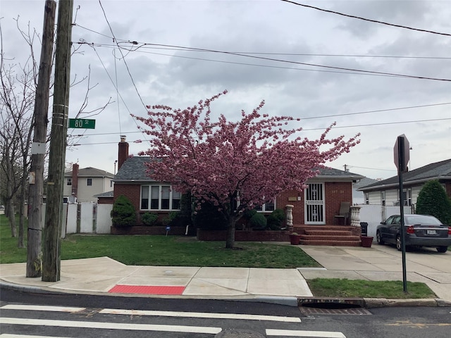15731 80th St, Howard Beach, NY 11414 - obstructed view of property with a front yard, fence, a chimney, and brick siding