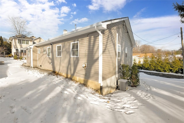 view of snowy exterior with central AC unit