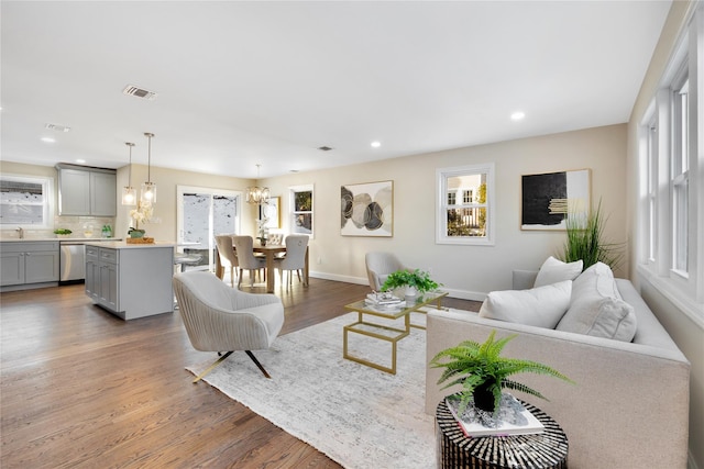 living room featuring an inviting chandelier and wood-type flooring