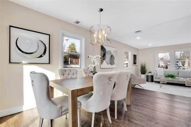 dining space with a notable chandelier and hardwood / wood-style flooring