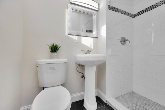 bathroom with sink, a tile shower, tile patterned floors, and toilet