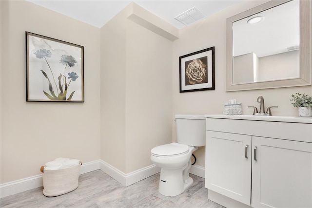 bathroom featuring vanity, wood-type flooring, and toilet