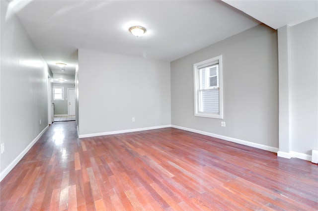 spare room featuring wood-type flooring and a healthy amount of sunlight