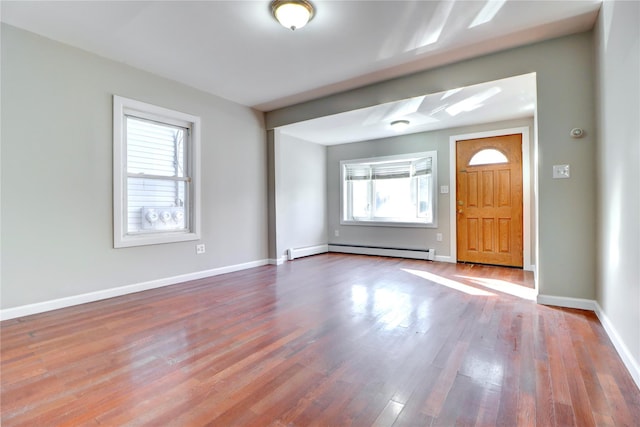 entrance foyer featuring a baseboard heating unit and wood-type flooring