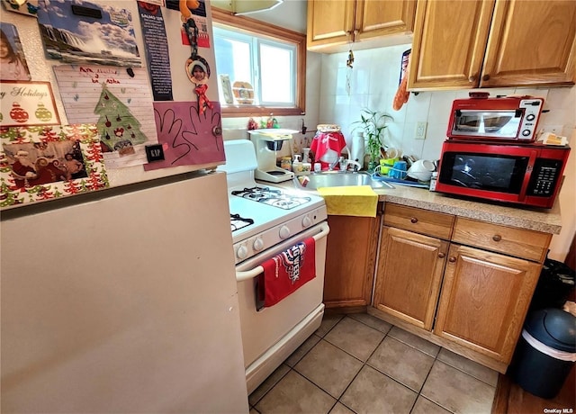 kitchen featuring light tile patterned floors and white appliances