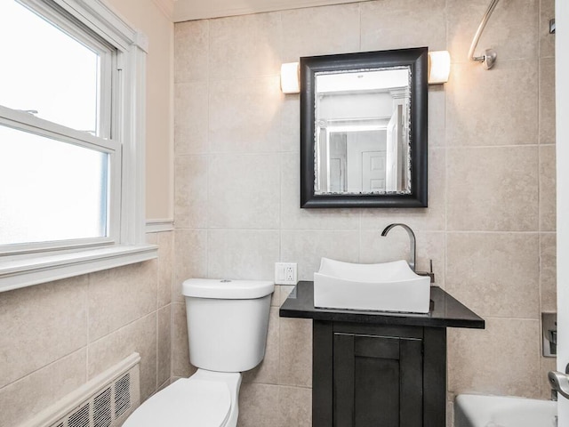 bathroom with vanity, tile walls, and toilet