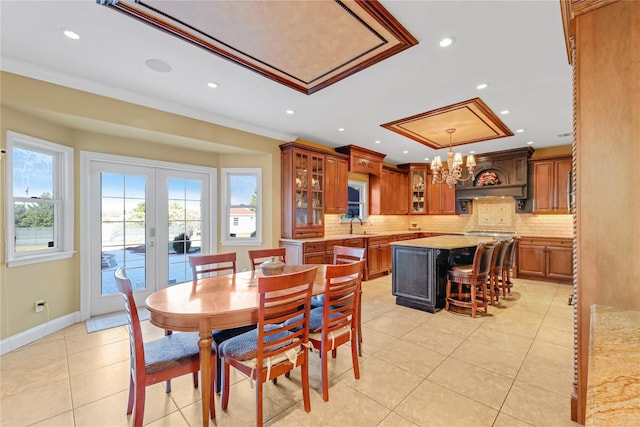 dining space featuring crown molding, sink, light tile patterned floors, and french doors