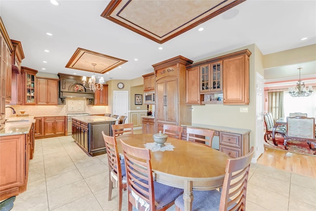 dining area featuring light tile patterned flooring, sink, and a notable chandelier